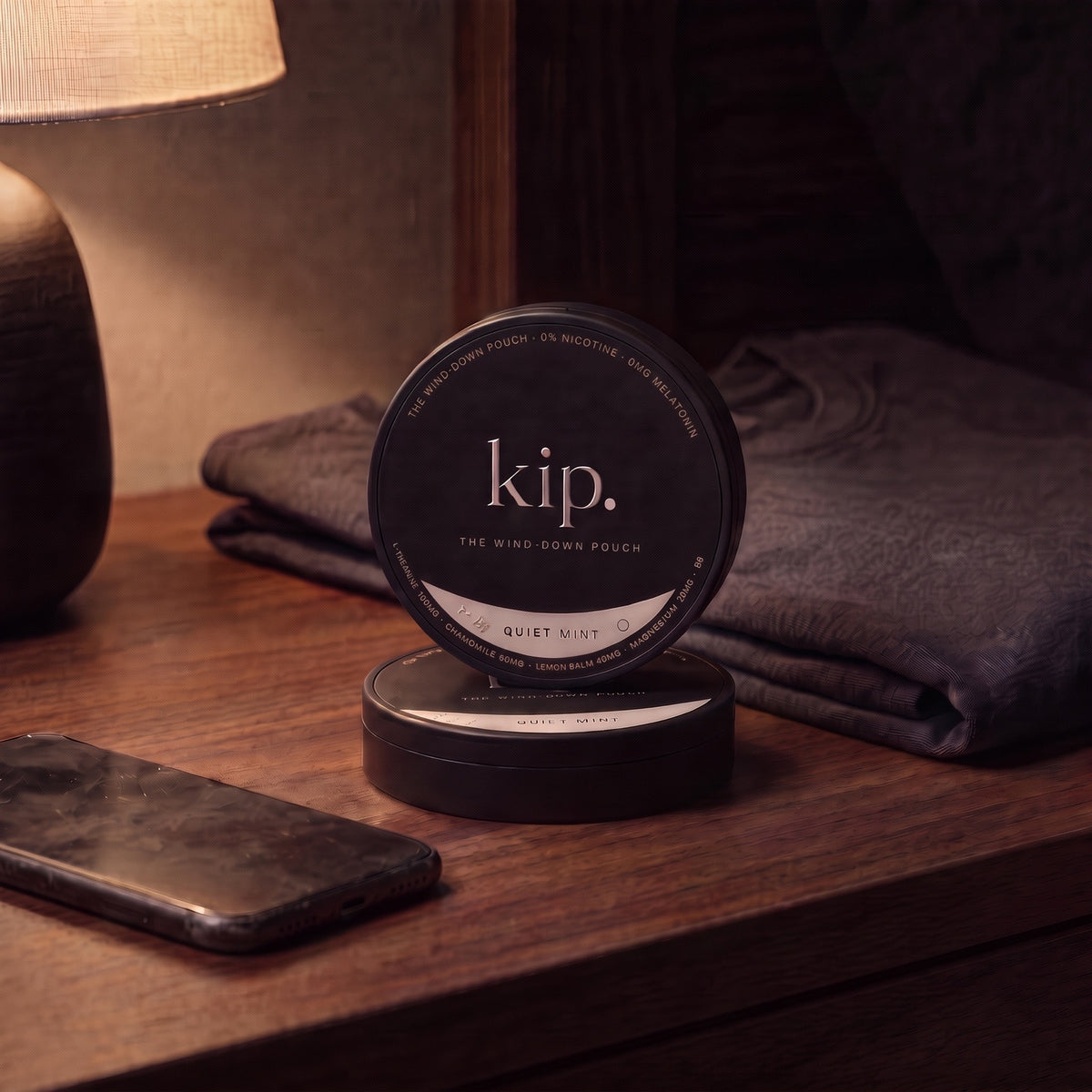 The kip tin resting on a bed at dusk, window fading to blue behind